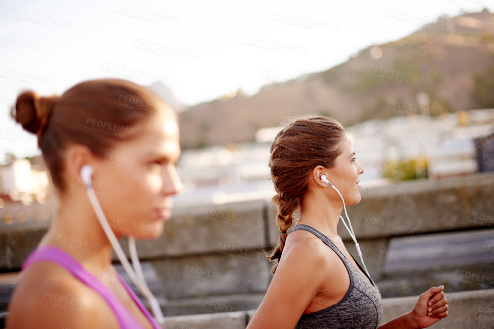Buy stock photo Music, running and fitness with women in city for health podcast, workout and exercise playlist. Runner, wellness and earphones with people training for sports athlete, twin sister or marathon