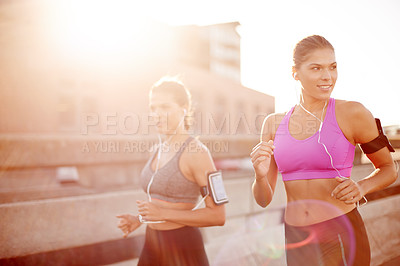 Buy stock photo Earphones, fitness and sisters on bridge for running with marathon training with music in city. Sports, lens flare and women twins with audio tech for cardio workout or exercise in town together.