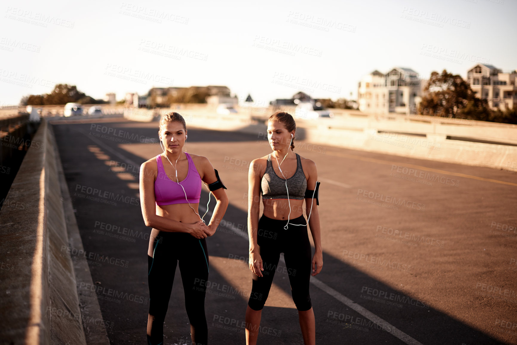 Buy stock photo Fitness, teamwork and women in portrait outdoor for cardio workout, running music or ready for exercise. Twin sisters, people and listening to radio on bridge for morning jog, performance or wellness