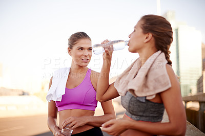 Buy stock photo Exercise, city and women on road with water break for marathon training, cardio workout and fitness challenge. Athletes, twin sisters and urban run for endurance, hydration wellness and goal together