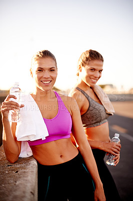 Buy stock photo Women, water and portrait in city for fitness, wellness or bonding for relationship development. Twin sisters, smile or relax in urban Portugal on exercise break, rest or family support for self care