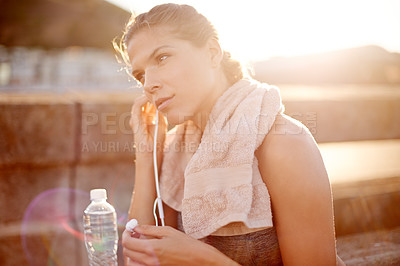 Buy stock photo Fitness, woman and thinking in city with earphones, exercise break or music for mindset. Runner, resting or outdoor with technology for podcast, audio book or ready with training schedule in Portugal