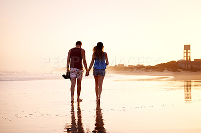 Buy stock photo Couple, holding hands and walking together at beach for holiday adventure, sunset date and bonding. Back space, people and romantic stroll on sand for sightseeing, explore nature and relationship fun