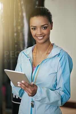 Buy stock photo Shot of a gym instructor holding a digital tablet