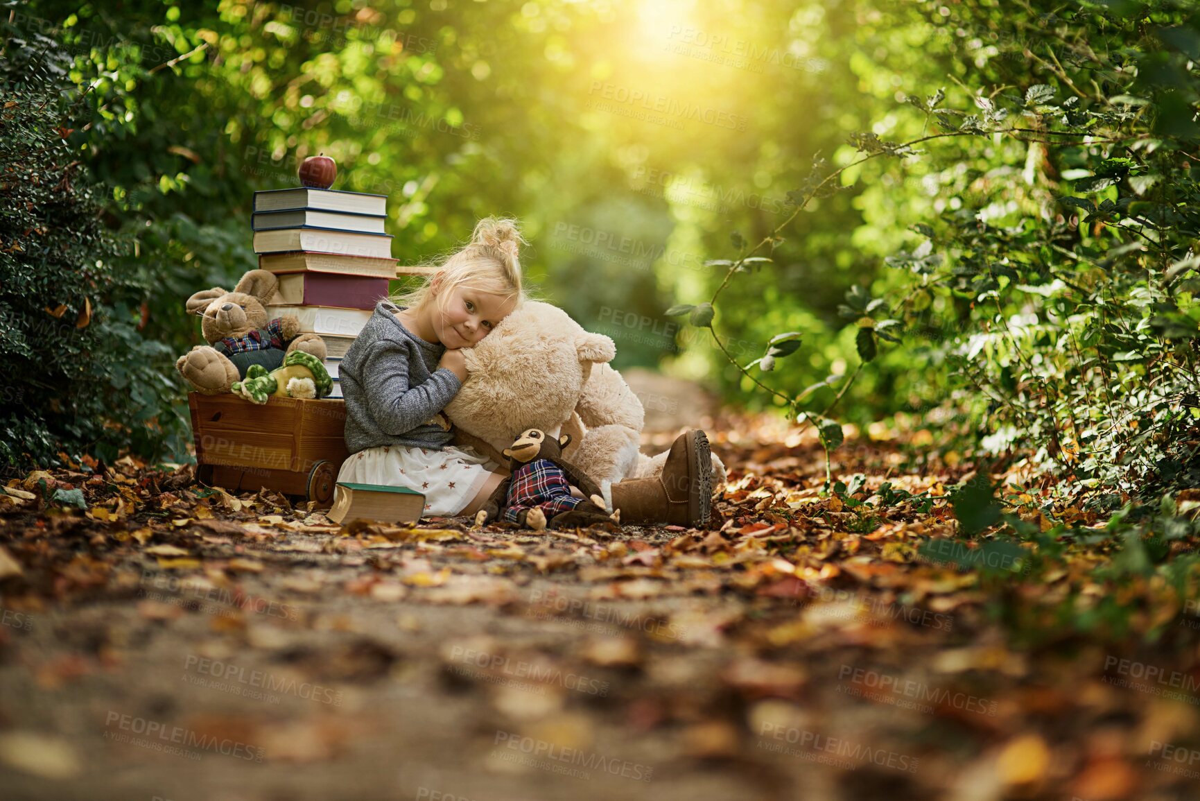 Buy stock photo Books, teddy bear and portrait of child in forest for learning, education and reading fairytale. Happy, lens flare and young girl with toys in nature, natural park and enchanted woods for adventure