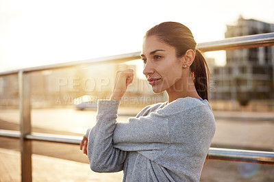 Buy stock photo Fitness, exercise and woman stretching in city for healthy body, wellness or prepare for practice at sunset. Warm up arm, outdoor and female runner training, workout and ready for sports marathon