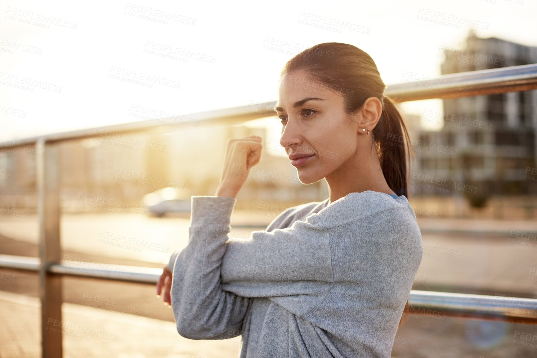 Buy stock photo Fitness, exercise and woman stretching in city for healthy body, wellness or prepare for practice at sunset. Warm up arm, outdoor and female runner training, workout and ready for sports marathon
