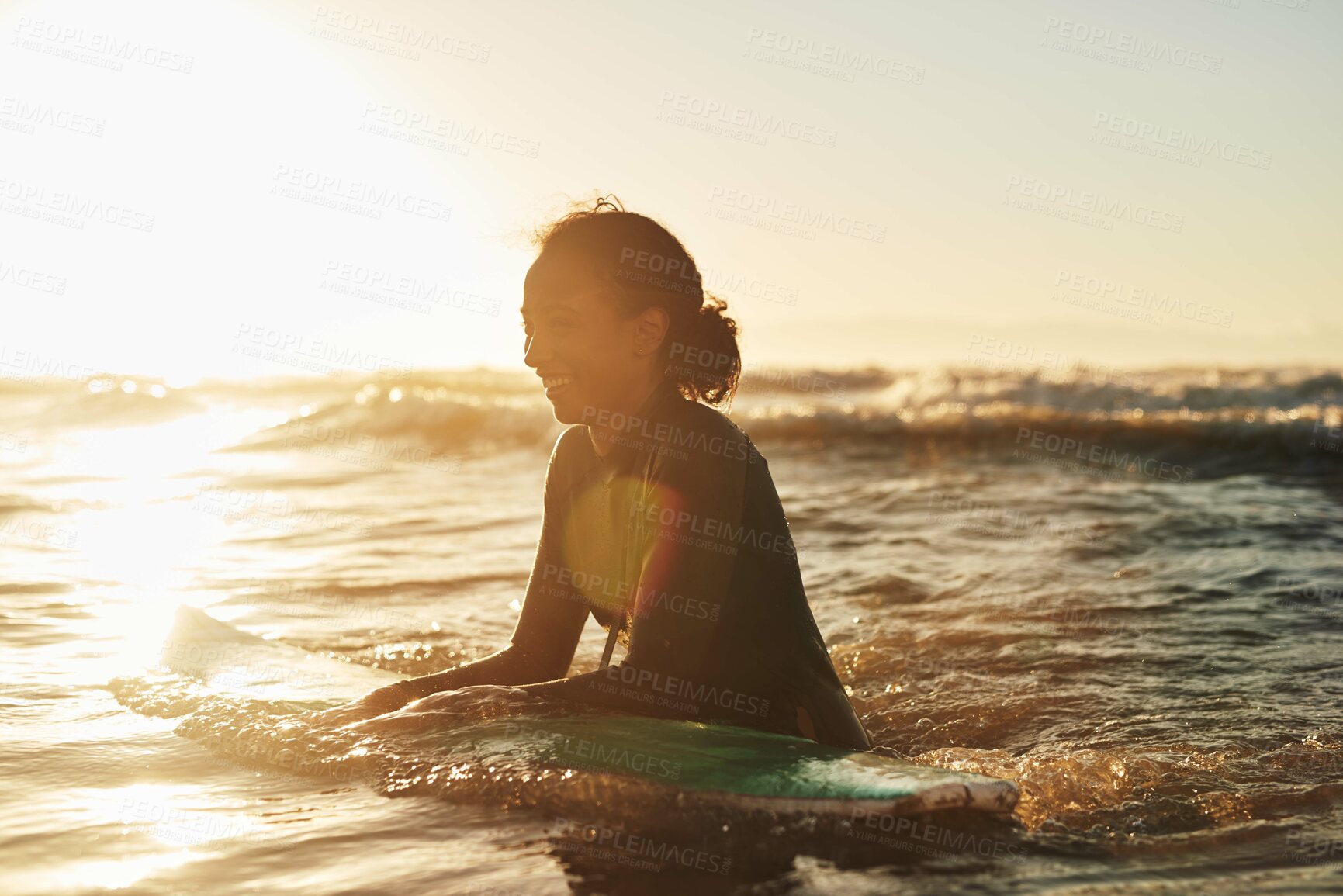 Buy stock photo Surfer, woman and swimming in ocean with wetsuit for summer adventure, sunset and fun activity in water. Girl, surfing sport and floating in waves with board for vacation travel, exercise and peace