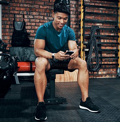 Buy stock photo Fitness, phone and happy man typing in gym for membership, training progress or body health update. Sport club, mobile or athlete check workout schedule, text or reading info for exercise tips on app