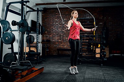 Buy stock photo Woman, jump rope and fitness in gym with workout for muscle development with training, health and wellness. Person, balance and challenge with cardio for transformation, change and exercise at club