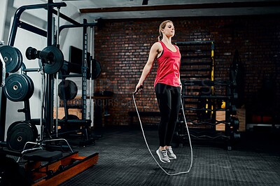 Buy stock photo Woman, jump rope and exercise in gym with workout for muscle development with training, health and wellness. Person, balance and challenge with cardio for transformation, change and fitness at club