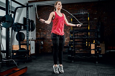 Buy stock photo Woman, jump rope and training in gym with workout for muscle development with exercise, smile and wellness. Person, balance and challenge with cardio for transformation, change and fitness at club