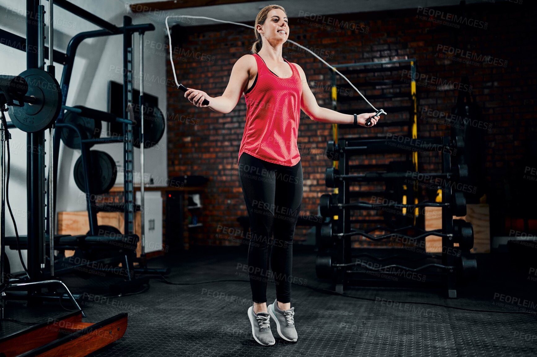 Buy stock photo Woman, jump rope and training in gym with workout for muscle development with exercise, smile and wellness. Person, balance and challenge with cardio for transformation, change and fitness at club