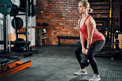 Buy stock photo Fitness, athlete and woman with kettle bell in gym, serious and health for energy, body and wellness. Training, equipment and person in club for workout, cardio and muscle for bodybuilder and girl