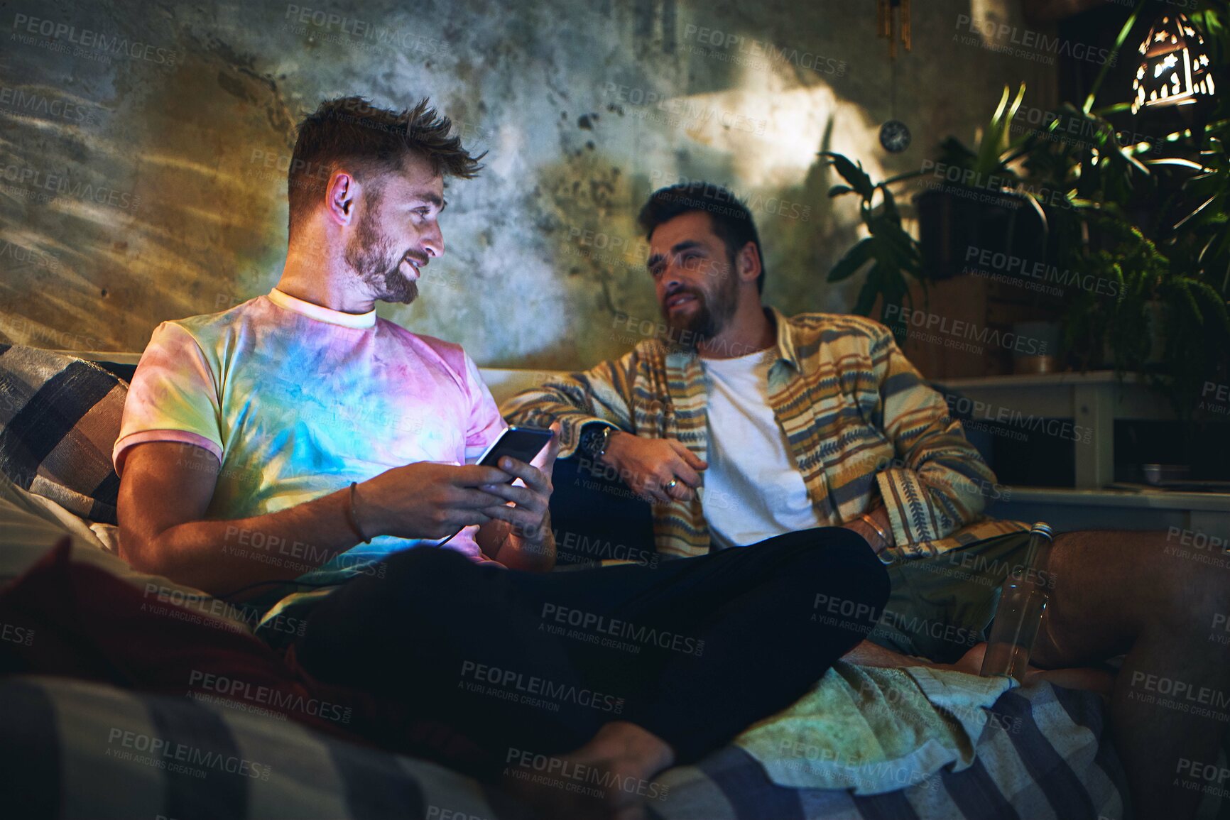 Buy stock photo Night, men and friends on sofa with smartphone, social media or bonding discussion together in home. Weekend, relax and people on phone, online chat or video streaming on couch in dark living room