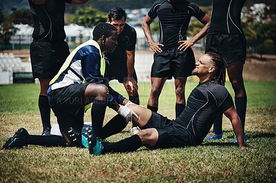 Buy stock photo Cropped shot of a young rugby player receiving first aid assistance on the field