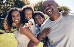 Cheerful young african american parents playing with their little sons in the garden. Excited mother and father carrying their sons on piggyback rides. Smiling couple enjoying a day in the park