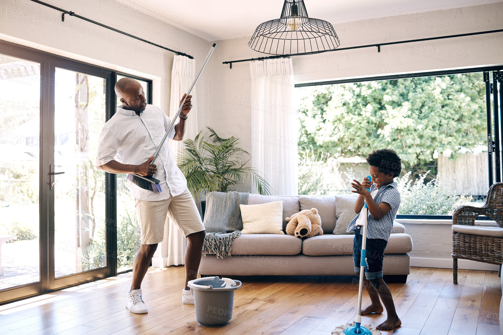 Buy stock photo Fun, child and man with broom, home and playing with son, chores and cleaning of living room and music. Singing, father and boy with equipment for hygiene, silly and black people in lounge and house