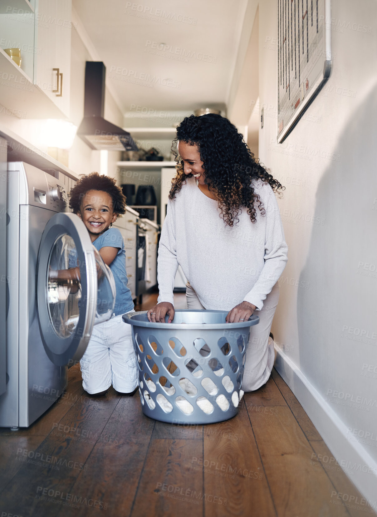 Buy stock photo Home, mother and child with machine for laundry, household chores and kid development with parent. House, woman and happy boy in portrait for washing clothes, helping and learning with mom at night