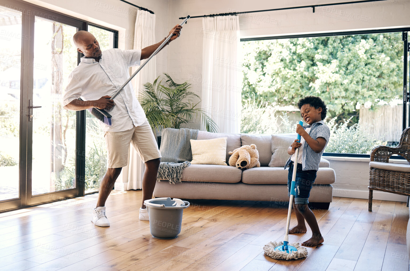 Buy stock photo Playing, child and man with broom, home and fun with son, chores and cleaning of living room and music. Singing, father and boy with equipment for hygiene, silly and black people in lounge and house