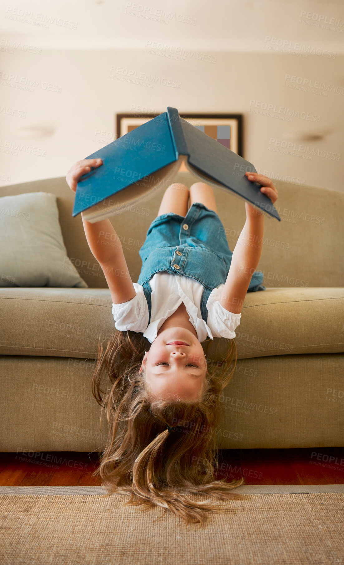 Buy stock photo Child, girl and relax on couch with reading book of learning, fantasy story and language development. Kid, rest and upside down on sofa with novel for literature, storytelling and  education at house