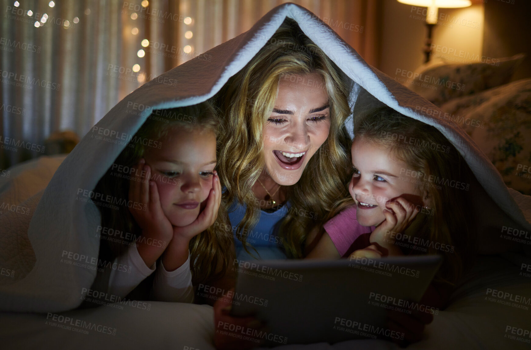 Buy stock photo Blanket, tablet and tent with family in bedroom of home at night for excitement or storytelling. Reading, streaming or video with mother and daughter children in apartment for bonding at bedtime