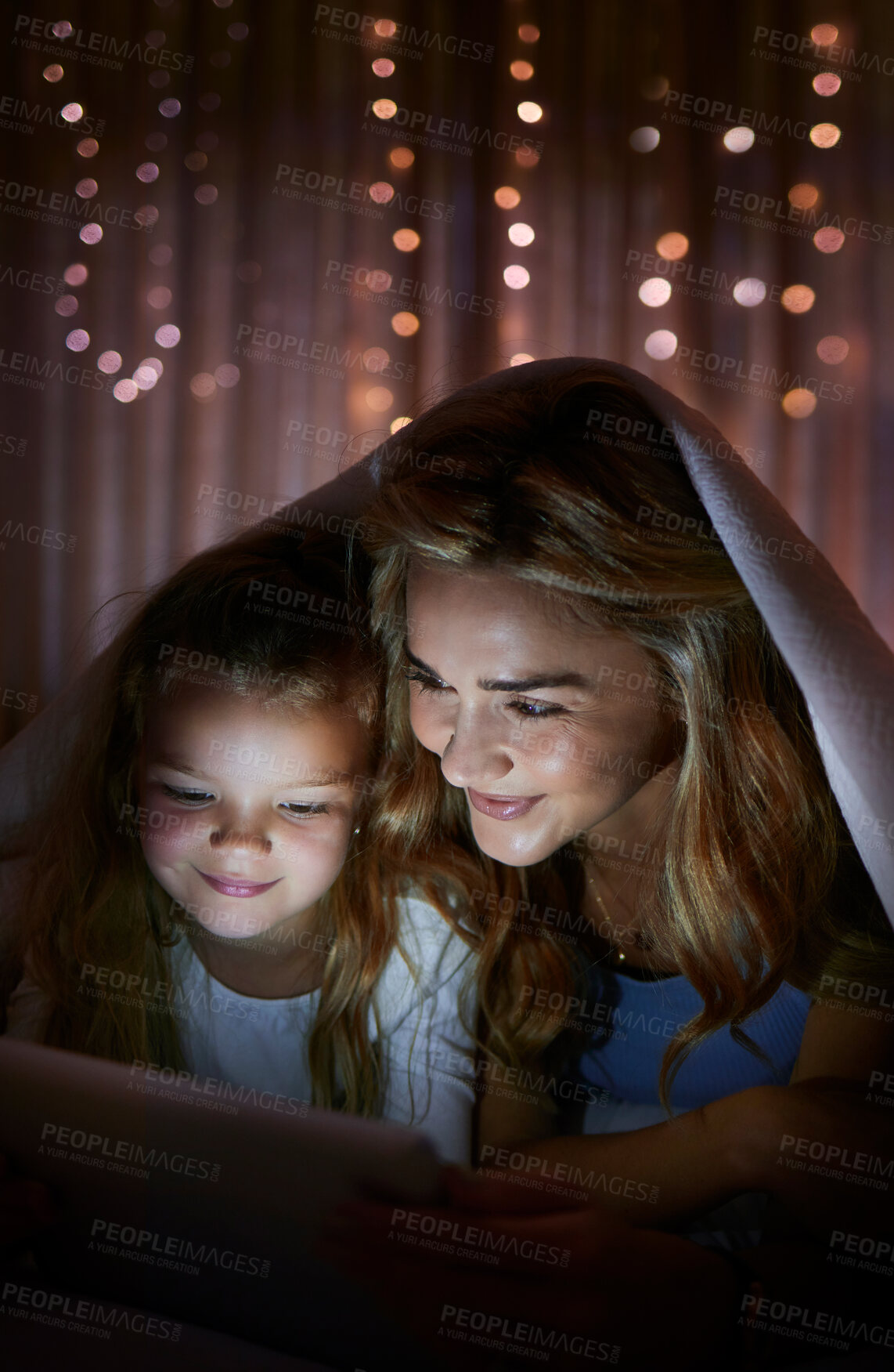 Buy stock photo Blanket, cover and tablet with family in bedroom of home at night for excitement or storytelling. Reading, smile or video streaming with mother and daughter in apartment for bonding at bedtime