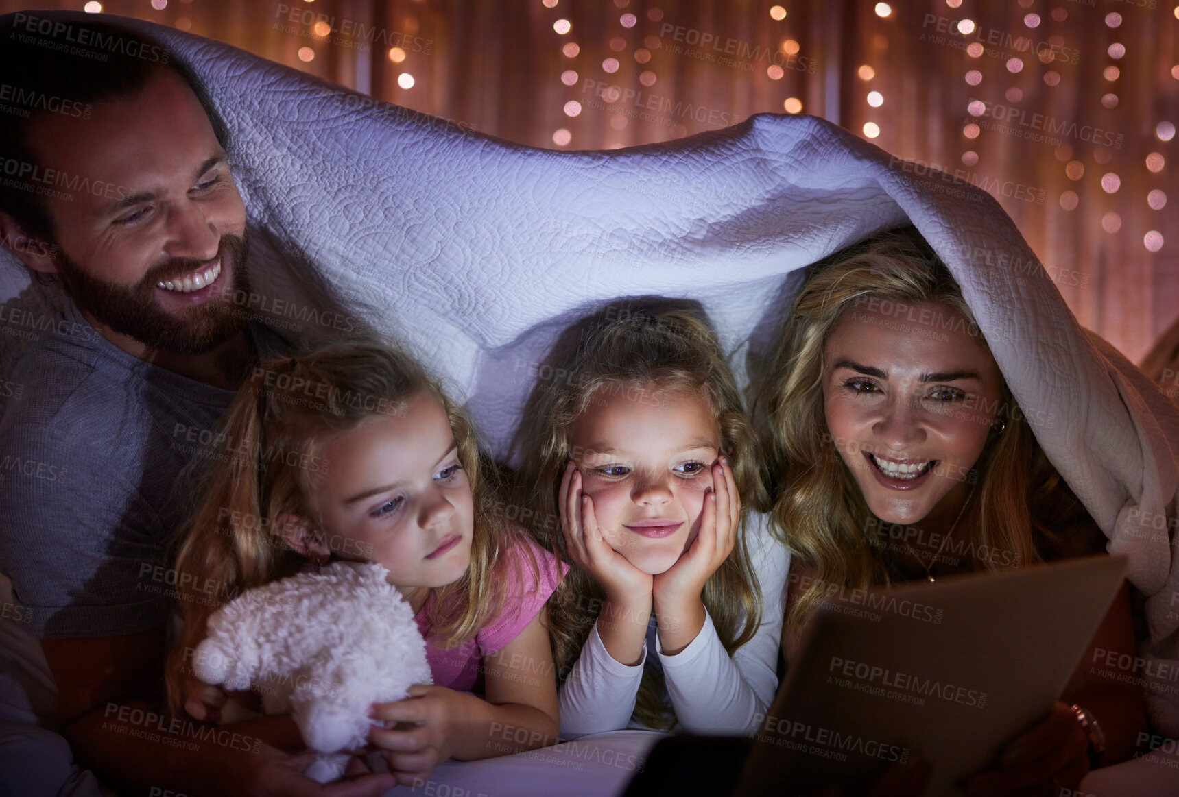 Buy stock photo Blanket, tablet and night with happy family in bedroom tent of home for excitement or storytelling. Reading, streaming or video with mom, dad and daughter kids in apartment for bonding at bedtime