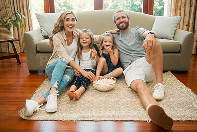 Buy stock photo Relax, popcorn and family in home watching tv, movie or show together for entertainment online. Happy, love and girl children streaming comic film with parents in living room for bonding on weekend