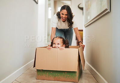 Buy stock photo Mother, daughter and playing in box in new home for mortgage celebration, real estate success and bonding. People, fun game and excited for relocation, property investment and security in dream house