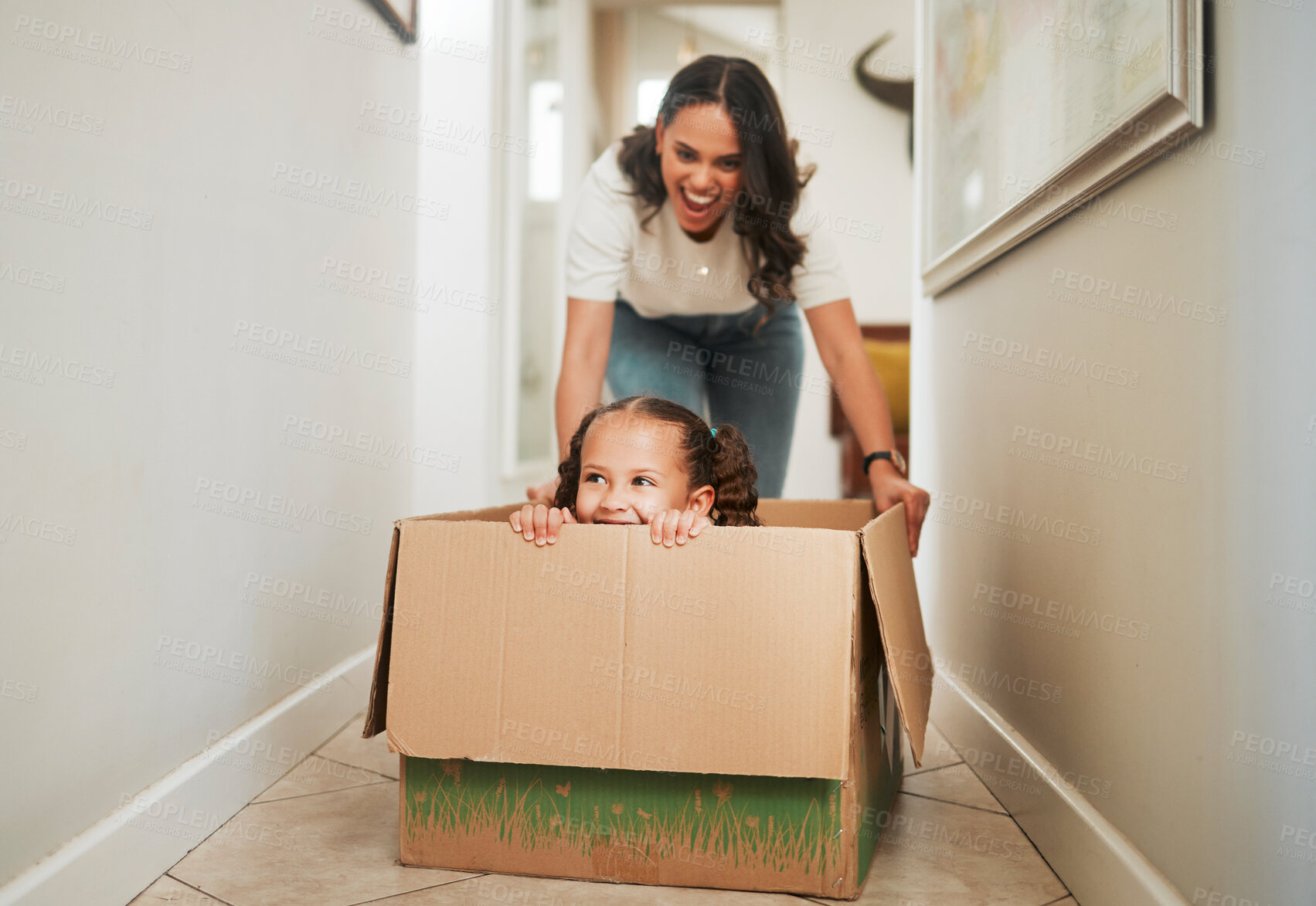Buy stock photo Mother, daughter and playing in box in new home for mortgage celebration, real estate success and bonding. People, fun game and excited for relocation, property investment and security in dream house