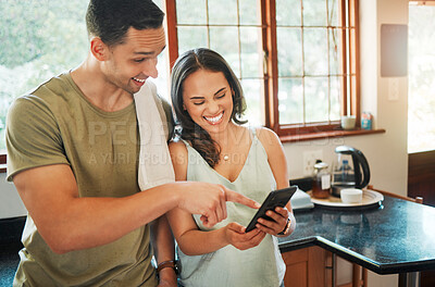 Buy stock photo Online, couple and laughing with phone in kitchen for social media meme, funny video or comedy blog. Love, happy people and pointing to smartphone in home for streaming service, mobile app or bonding