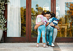 Children returning from school and hugging father on their return. Daddy missed little daughter and son holding children in arms hugging girl and boy while standing by the door