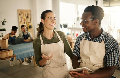 Buy stock photo Two happy, smiling and diverse business owners browsing online, searching the web and planning on tablet while working at a textile factory together. Creative designers smiling and looking at orders 