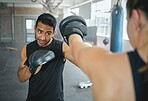 Boxer and coach training workout together at the sports fitness and wellness gym. Professional young martial arts athlete practice and exercise boxing with a personal trainer for a competitive fight