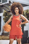 Basketball court, woman player or sports person with afro looking serious at training, workout and exercise or competition ball game. Fitness portrait of healthy athlete with motivation or vision