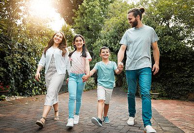 Buy stock photo Holding hands, smile and walking with family outdoor in neighborhood together for bonding. Love, safety or trust with happy mom, dad and children on brick road for development, growth or security