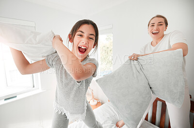 Buy stock photo Happy girl, pillow fight and portrait of mom on bed in morning together for fun bonding in home. Smile, child and excited kid playing games for laughing with cushions, mother or parent in bedroom