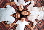 Portrait of a mixed race family laying on the floor at home. Hispanic family bonding while laying on the ground at home