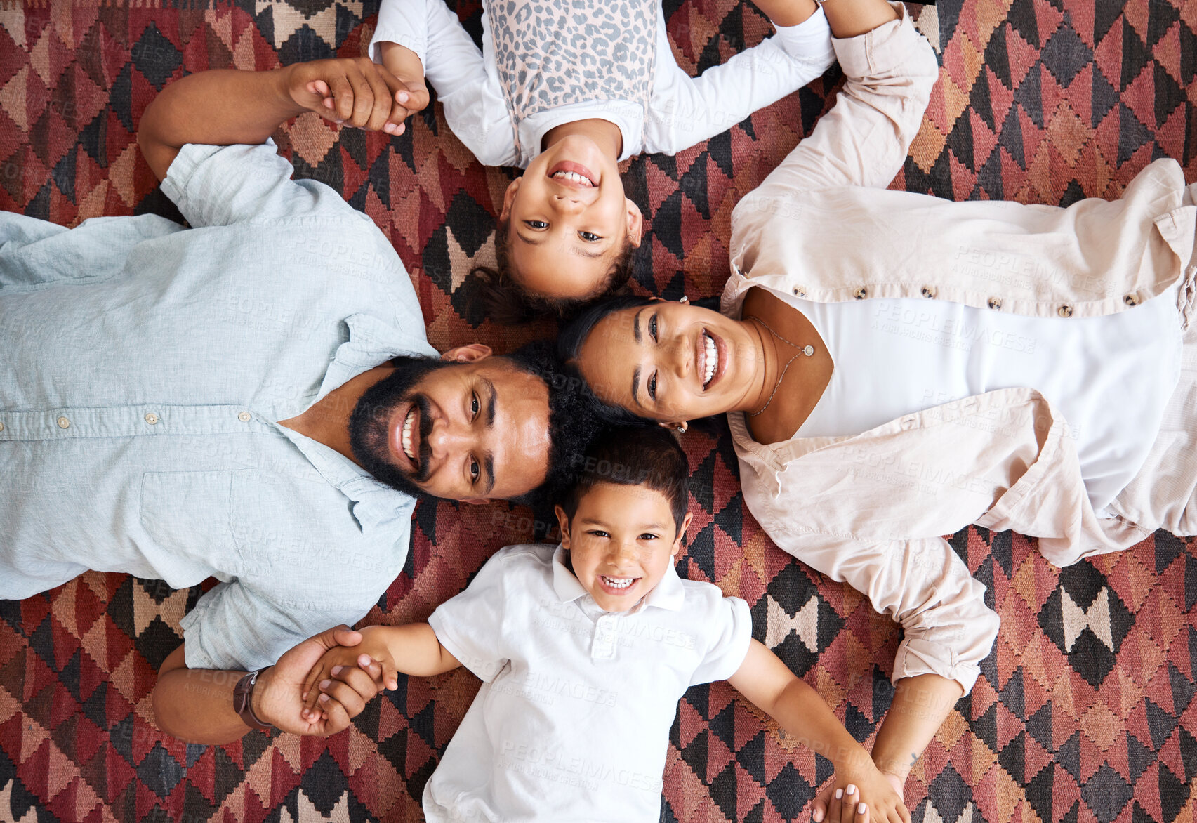 Buy stock photo Top view, holding hands and happy family with portrait in home for love, bonding or security. Smile, parents and kids siblings on living room floor with support, protection and relationship in Mexico