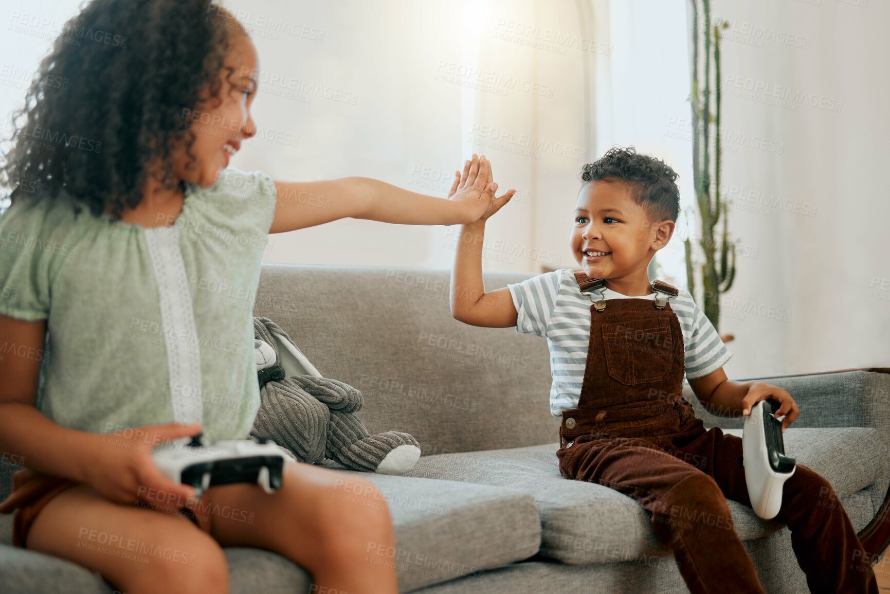 Buy stock photo High five, controllers and children on sofa with video game for bonding, weekend and relax in home. Happy, rest and kid siblings streaming electronic entertainment for fun in living room at house.