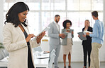 Young happy african american businesswoman working on a digital tablet in an office. One black female boss smiling and holding a digital tablet while in a meeting at work