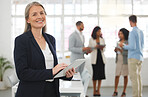 Portrait of a happy caucasian businesswoman working on a digital tablet in an office. One confident female boss smiling and holding a digital tablet while in a meeting at work