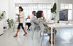 Group of diverse call center agents working in a busy office together. Businesspeople answering calls while working on a desktop computer at a desk in an office. Customer service workers wearing headsets at work