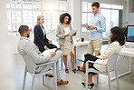 Group of five diverse businesspeople having a meeting in an office at work. Hispanic businesswoman reading a report to her colleagues in a workshop. Business professionals planning together