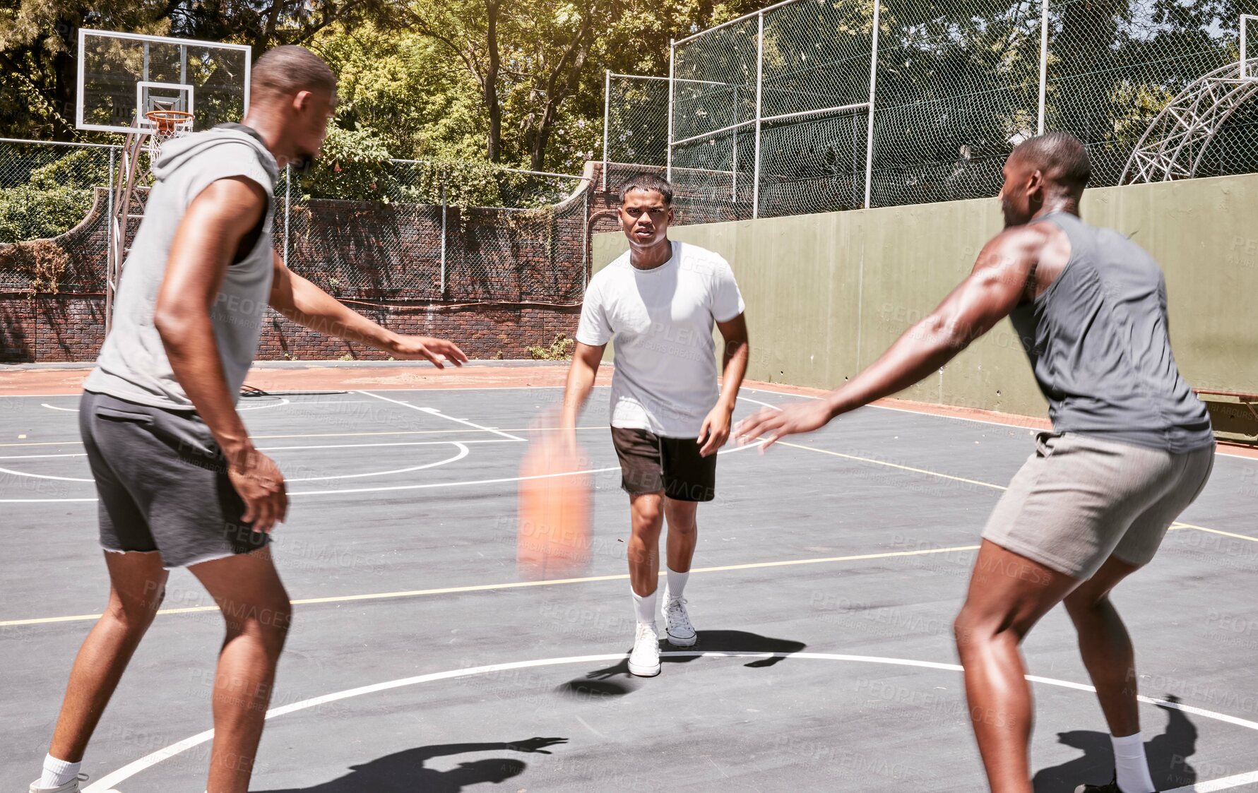 Buy stock photo Three african american men playing basketball on a court outdoors. Black man and his sporty friends being athletic outside. Group of basketball players competing in a match or game for recreation fun