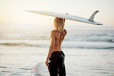 Buy stock photo Back, surfing and sports with a man on the beach, holding his surfboard over his head in the water. Surf, view and ocean with a shirtless male surfer standing in the sea for training from behind