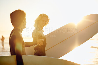 Buy stock photo Fist bump, surfer and friends by the waves with sunset lens flare ready for water sport in the ocean. Beach, men and motivation hand gesture of young people with a surfboard about to to start surfing
