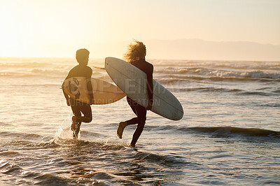 Buy stock photo Surfing, friends and running at sunset beach for waves, freedom and swim from behind. Silhouette, surfer and guys with board at sea, ocean and excited adventure on holiday, summer or fun water sports