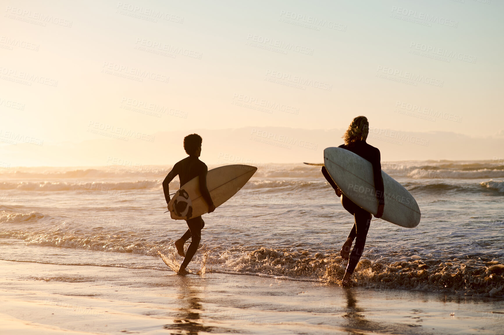 Buy stock photo Sunset, running and friends at the beach with surfboards for a hobby, waves and learning an activity. Calm, training and men in the water by the ocean for surfing, competition and sports in the sea